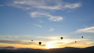 A fleet of colorful hot air balloons ascend into the painted canvas of the twilight sky, adding magic to Melbourne's skyline.